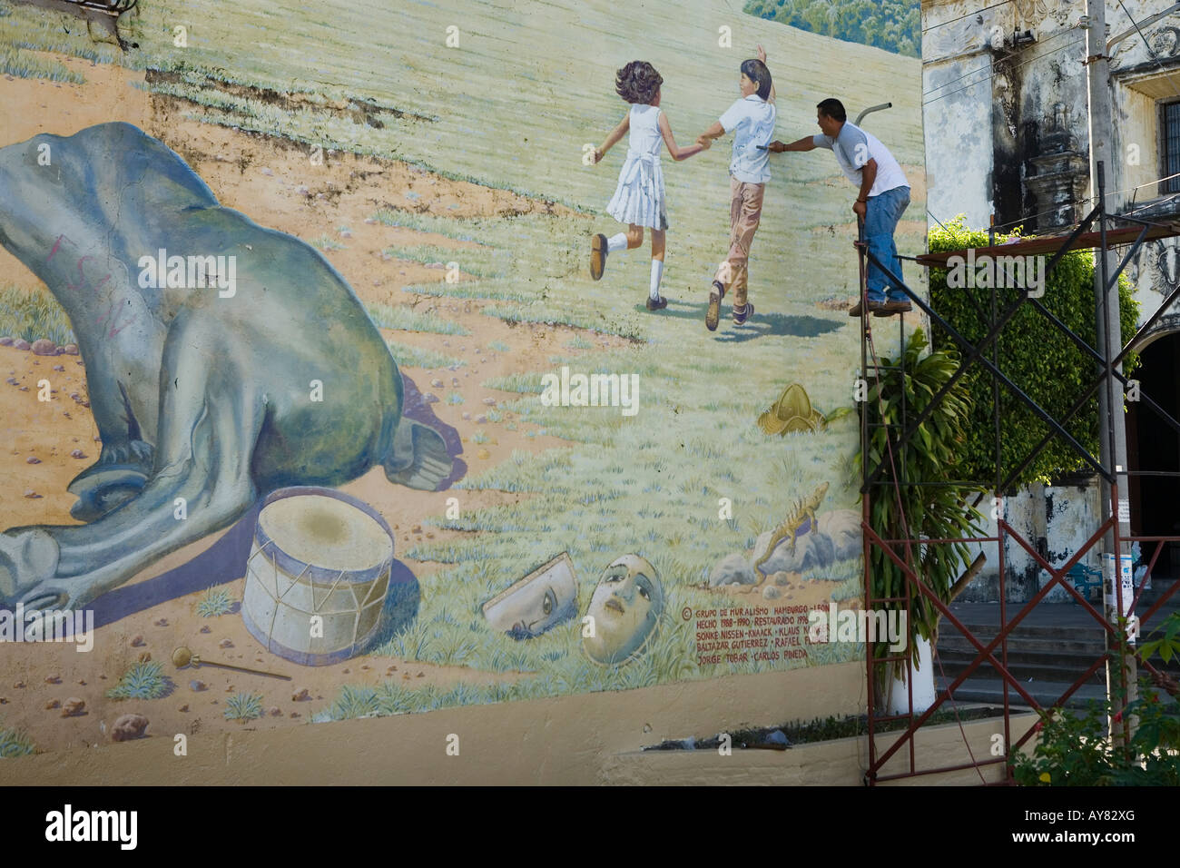Les hommes de l'installation d'un feu sur une fresque peinte Leon Nicaragua Banque D'Images