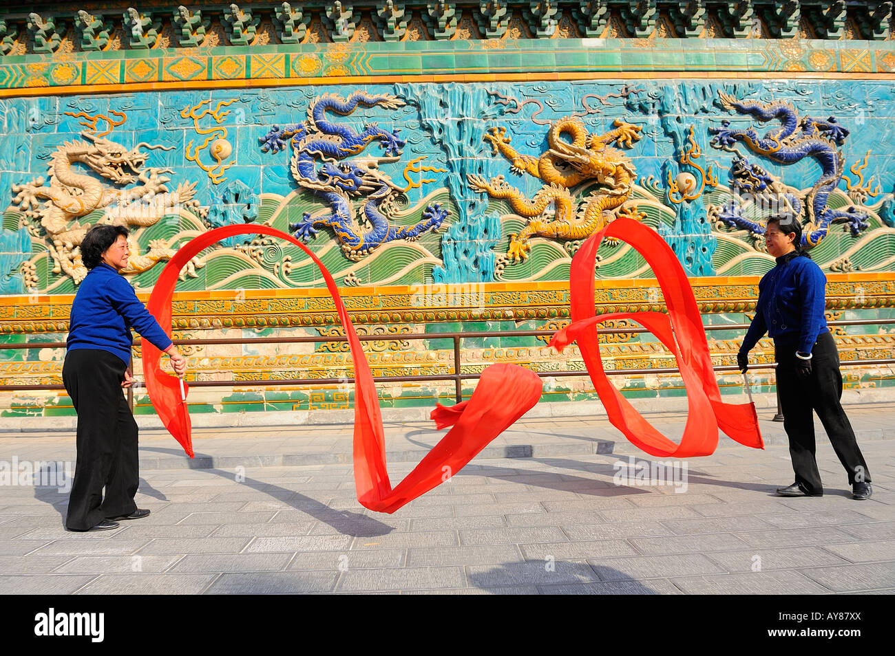 La femme chinoise Danse avec les soies rouge en face de neuf dragons au mur du parc Beihai à Pékin, en Chine. 05-Mar-2008 Banque D'Images
