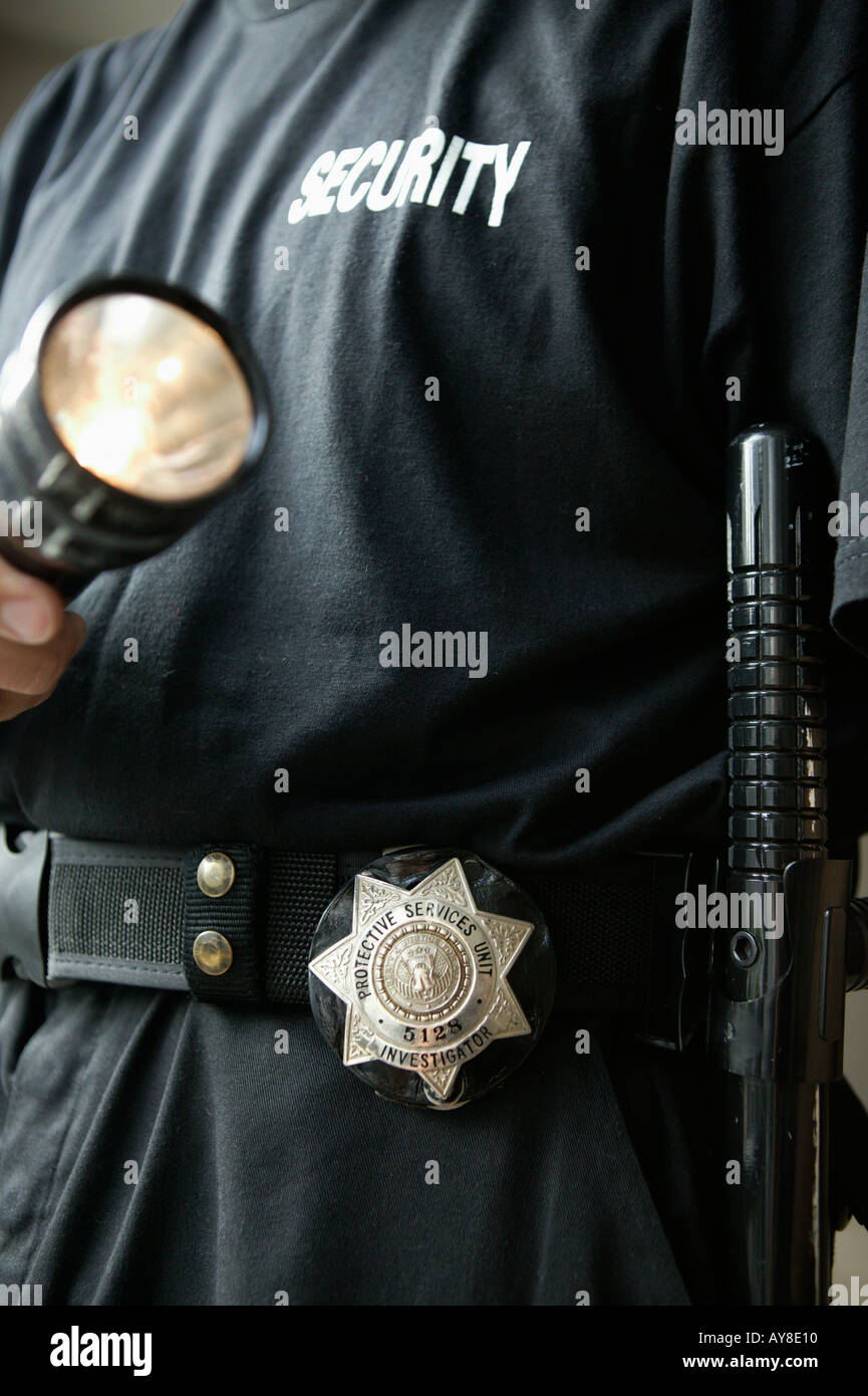 Agent de sécurité avec un insigne baton et lampe de contrôle des bureaux d'entreprise Banque D'Images