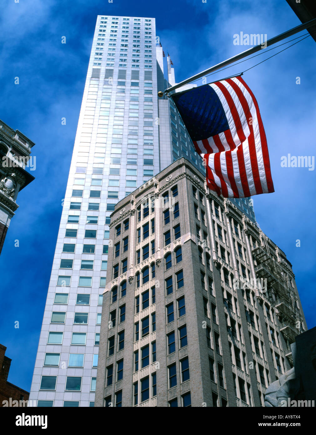 Low angle view of skyscrapers against blue sky with stars and stripes en premier plan. Banque D'Images