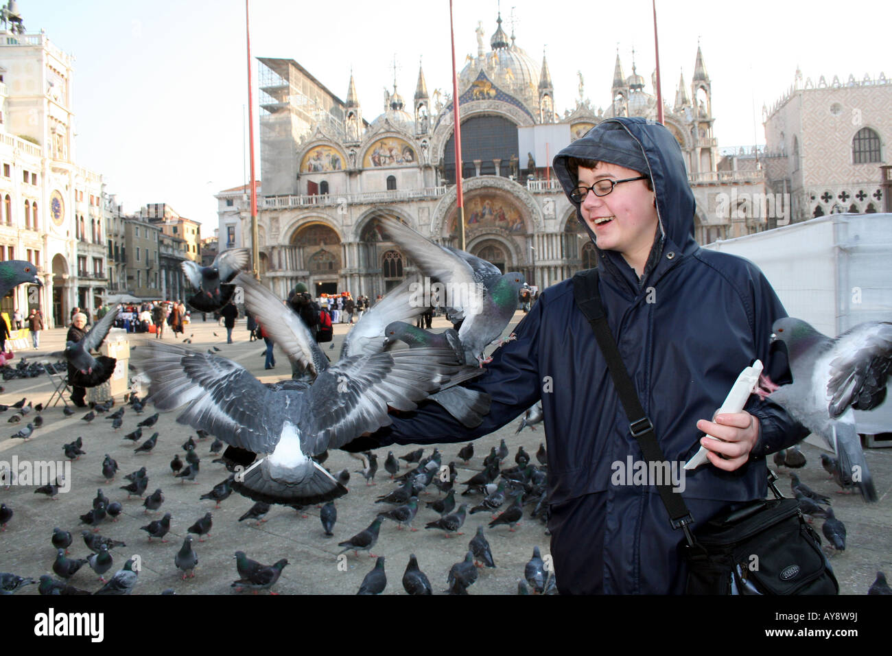 Boy Feeding Pigeons, San Marco, Venise, Italie Banque D'Images