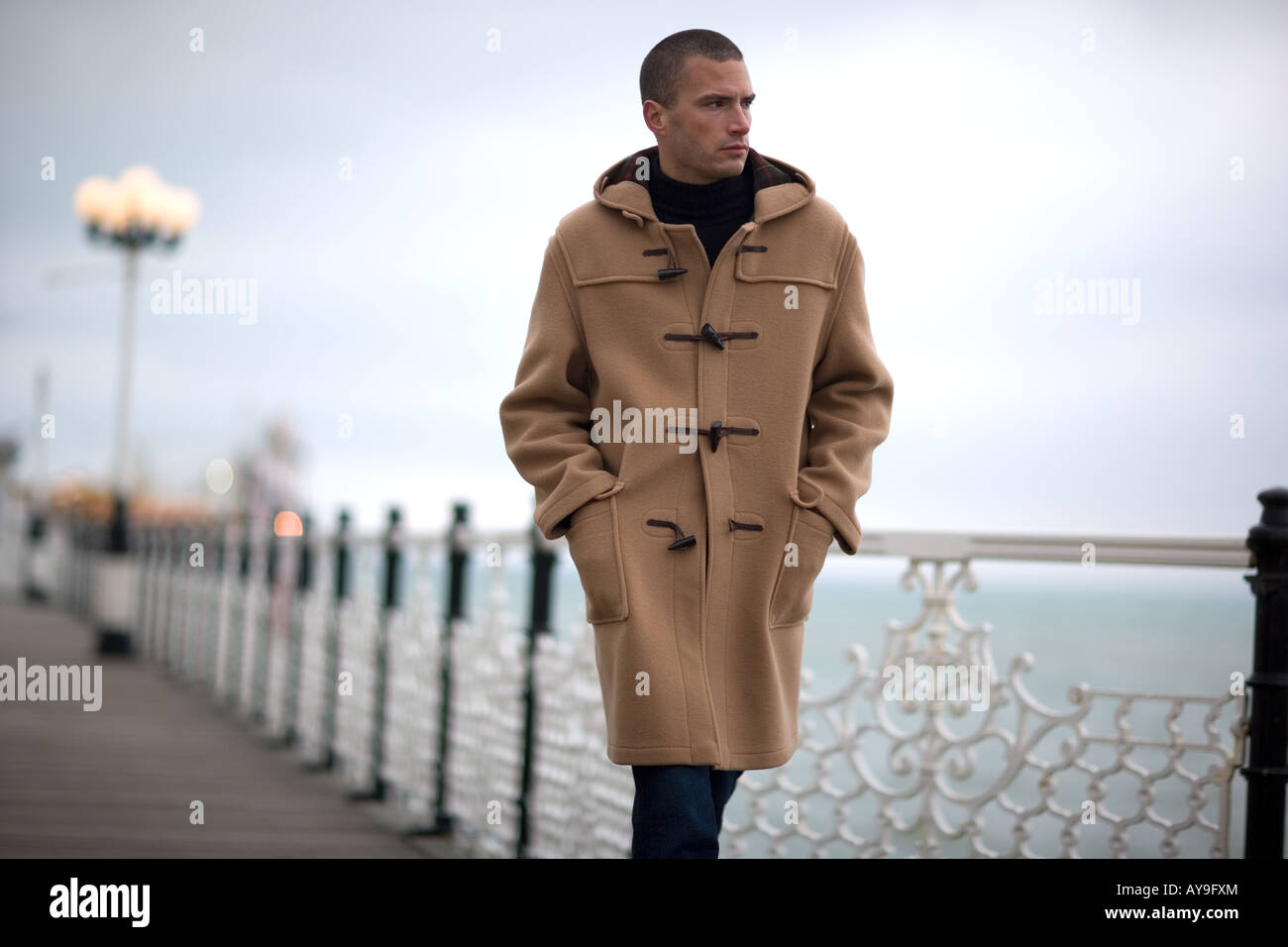 Dans l'homme duffle coat marcher le long de la jetée de Brighton,  Royaume-Uni Photo Stock - Alamy