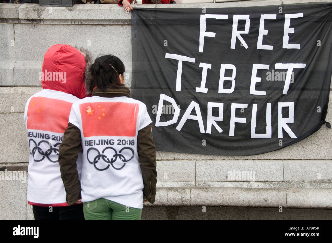 Deux partisans pro Chine en face de Tibet libre et Darfour banner Banque D'Images