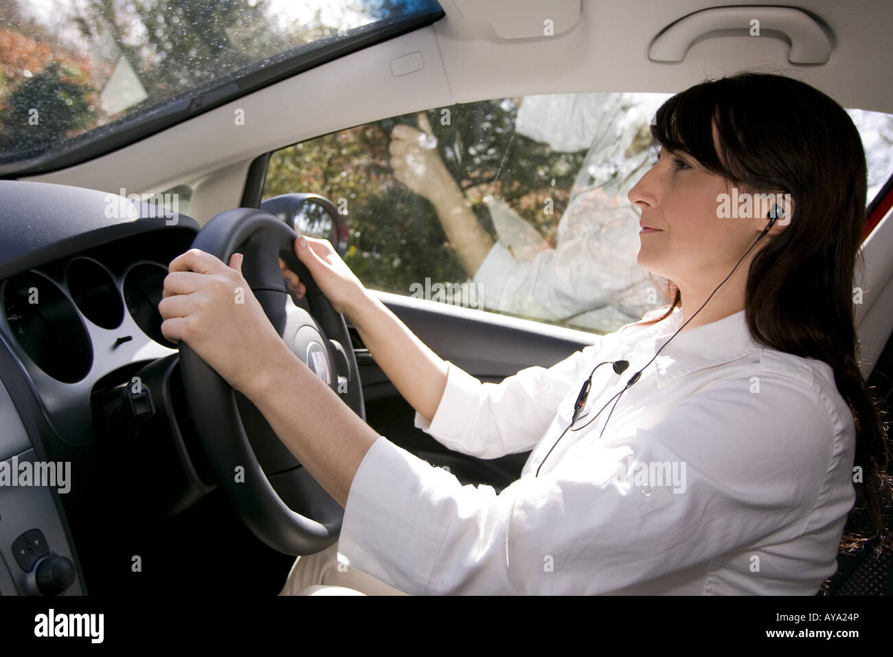 Femme à l'aide de téléphone mains libres en voiture Banque D'Images