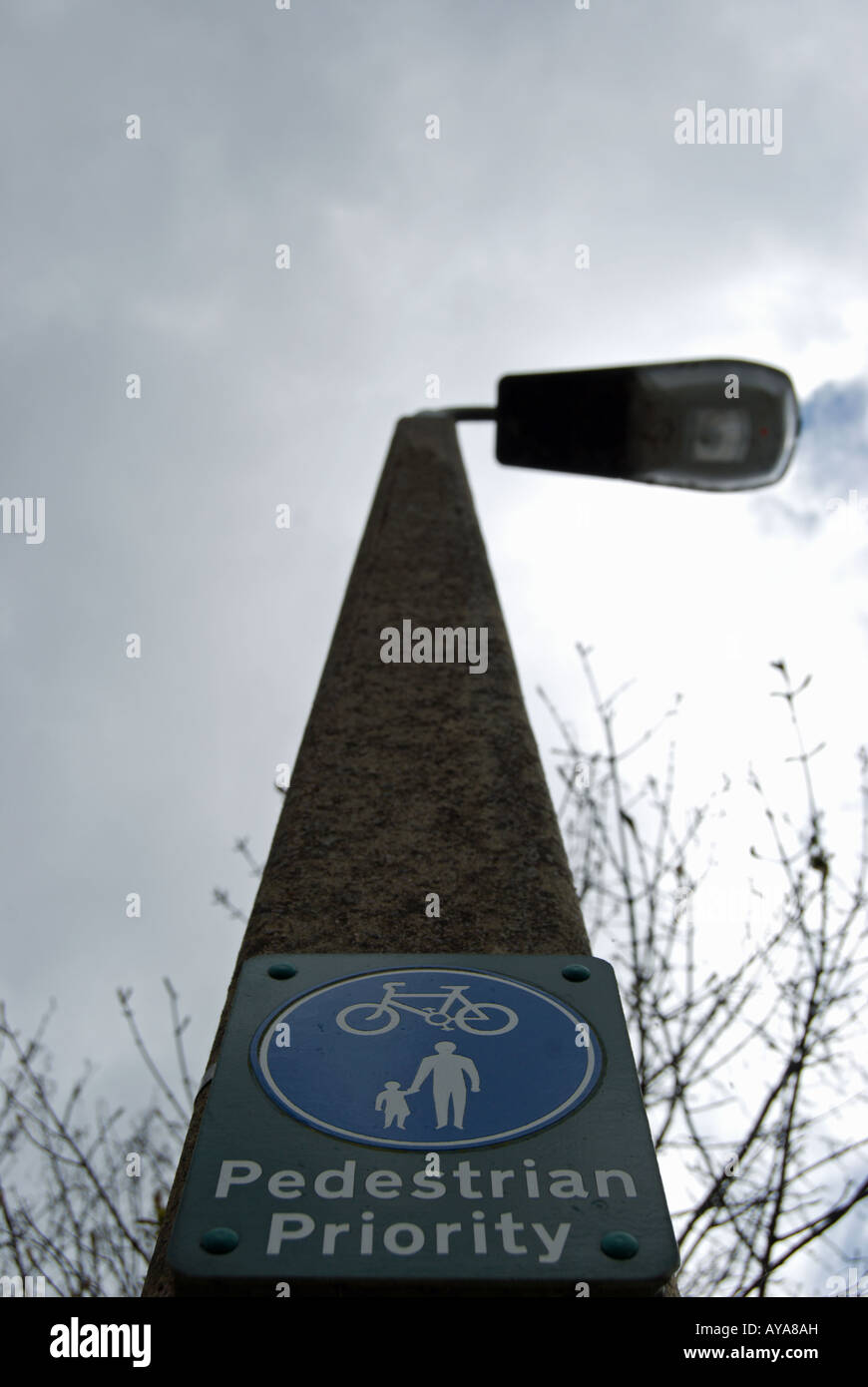 British sign fixé sur un lampadaire indiquant la priorité aux piétons sur un sentier aussi utilisé par les cyclistes. Banque D'Images