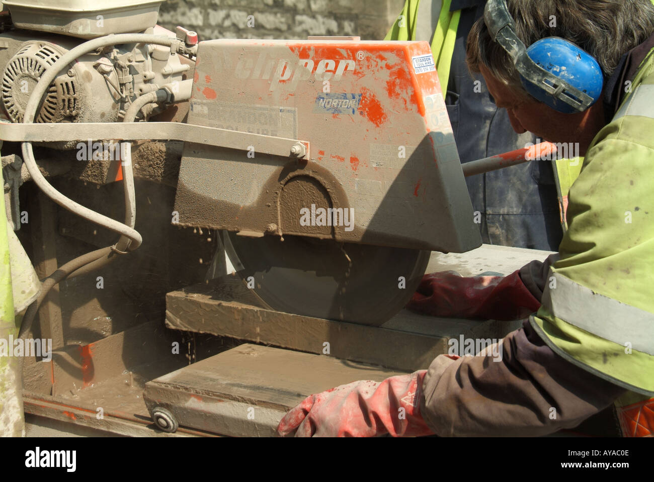 Close up de workman en utilisant un disque de coupe circulaire à haute vitesse à vu à travers des dalles pour les travaux de la rue Banque D'Images