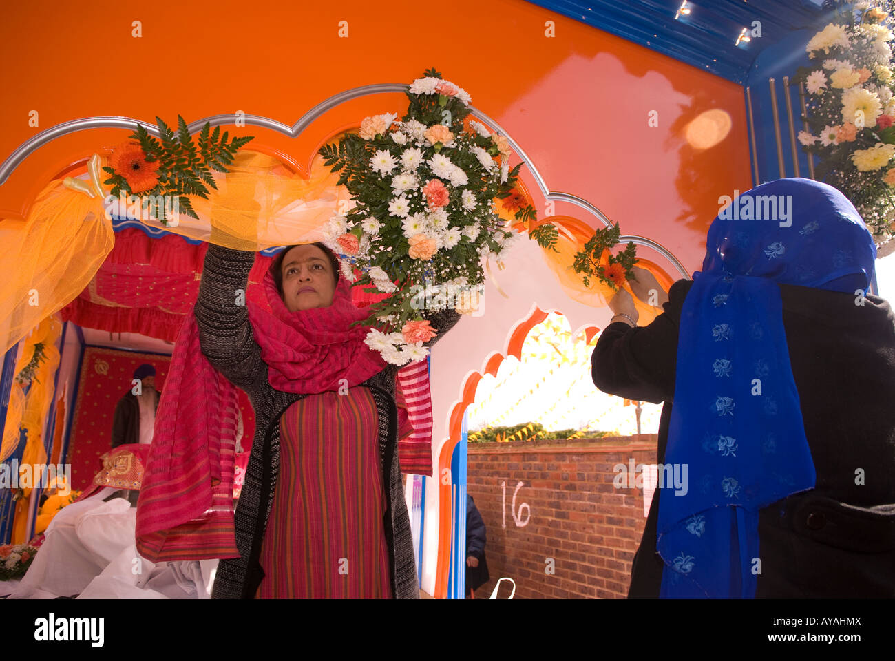 Les femmes sikhes finitions main à mettre des fleurs sur un char pour festival du Vaisakhi Hounslow Middlesex Royaume-Uni Mars 2008 Banque D'Images