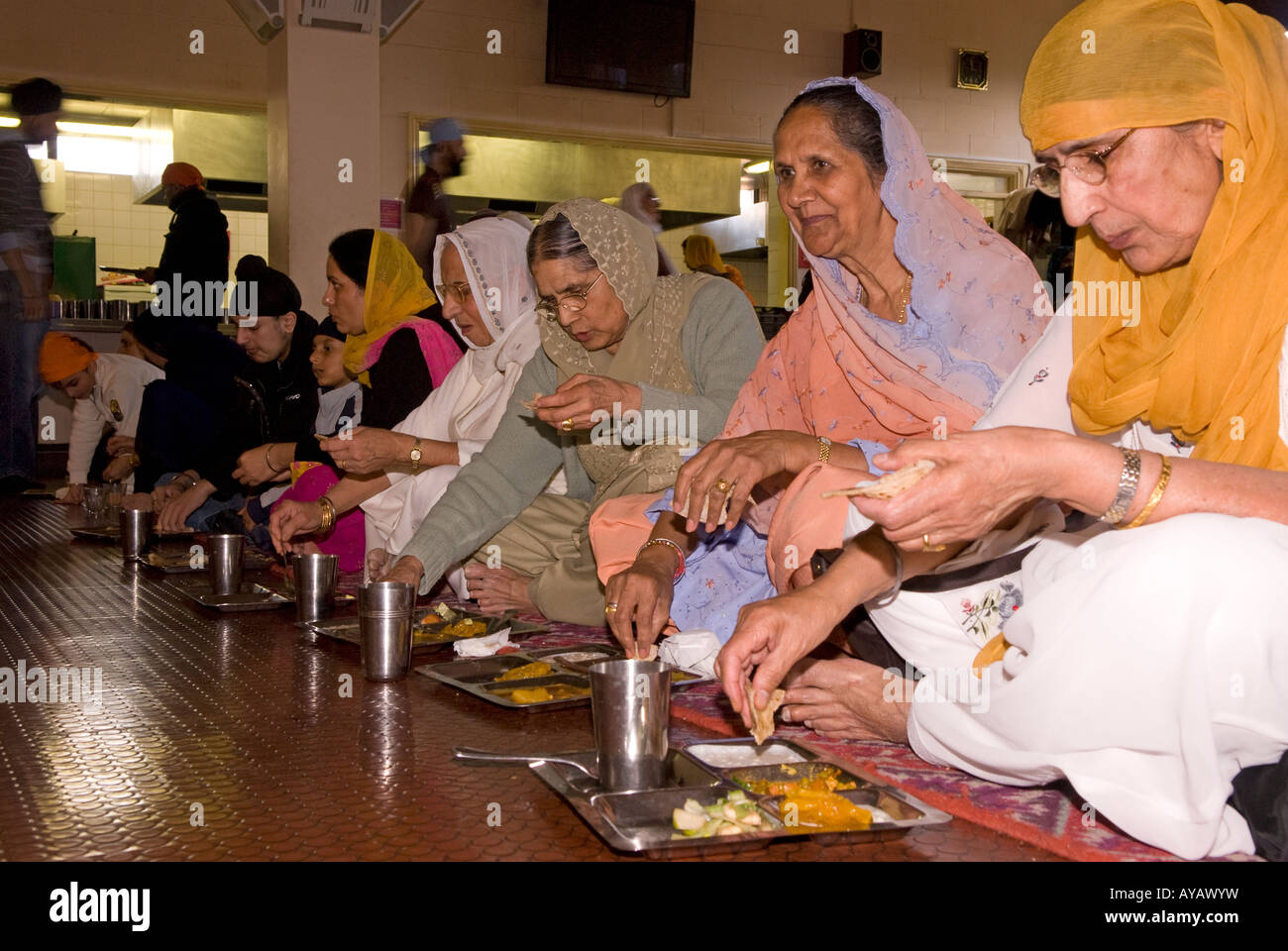 Les femmes sikhes à manger ou du temple Sikh Gurdwara Sri Guru Singh Sabha, Hounslow, Middlesex, Royaume-Uni. 30 Mars 2008 Banque D'Images