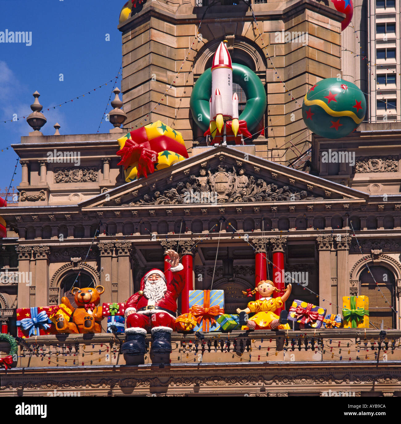 L'hôtel de ville façade décorée pour Noël avec d'énormes gonflés d'air, y compris les jouets le Père Noël en agitant dans Sydney, Australie Banque D'Images