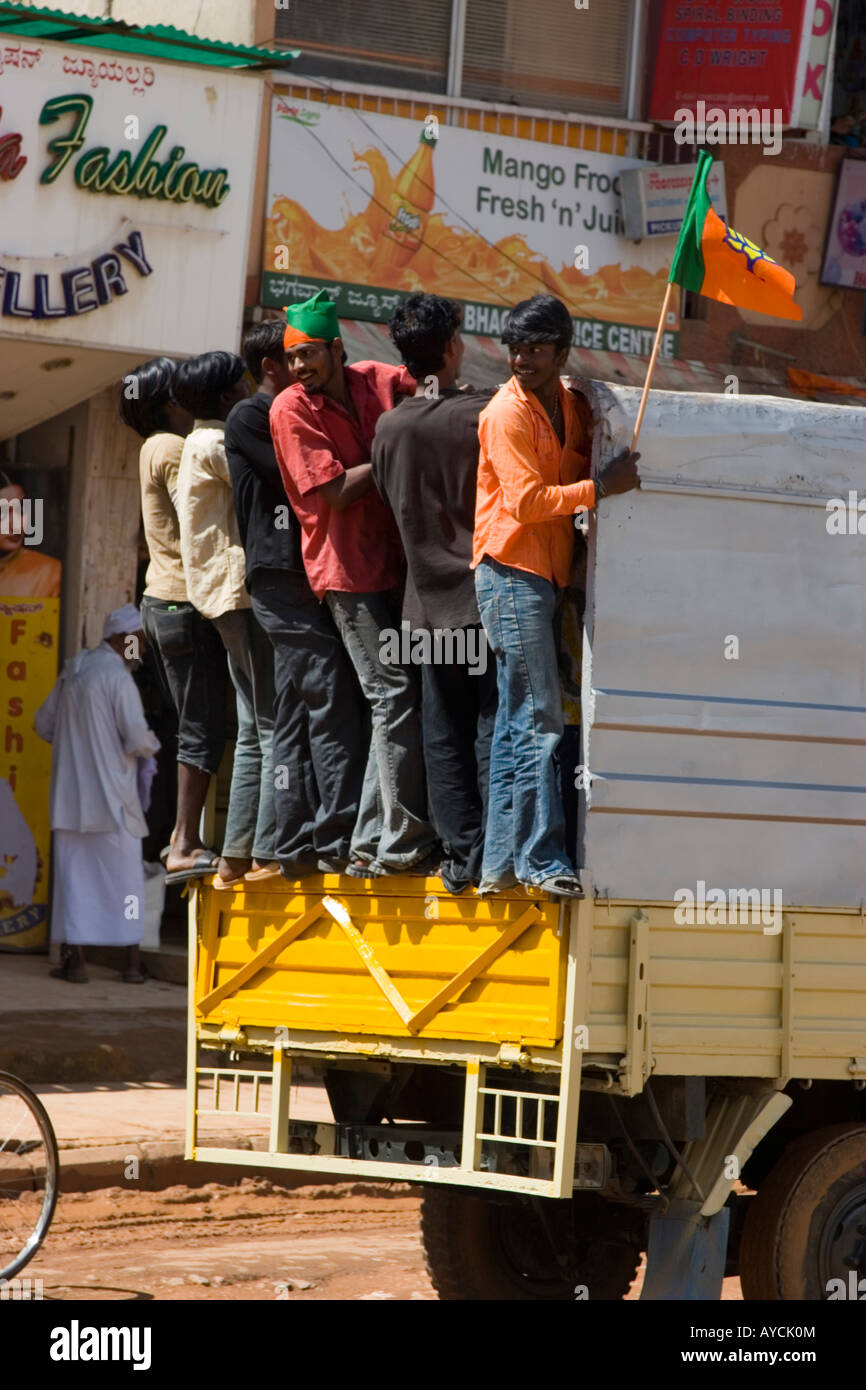 Les hommes l'attelage d'une ride sur l'arrière d'un camion à Bangalore Inde Banque D'Images