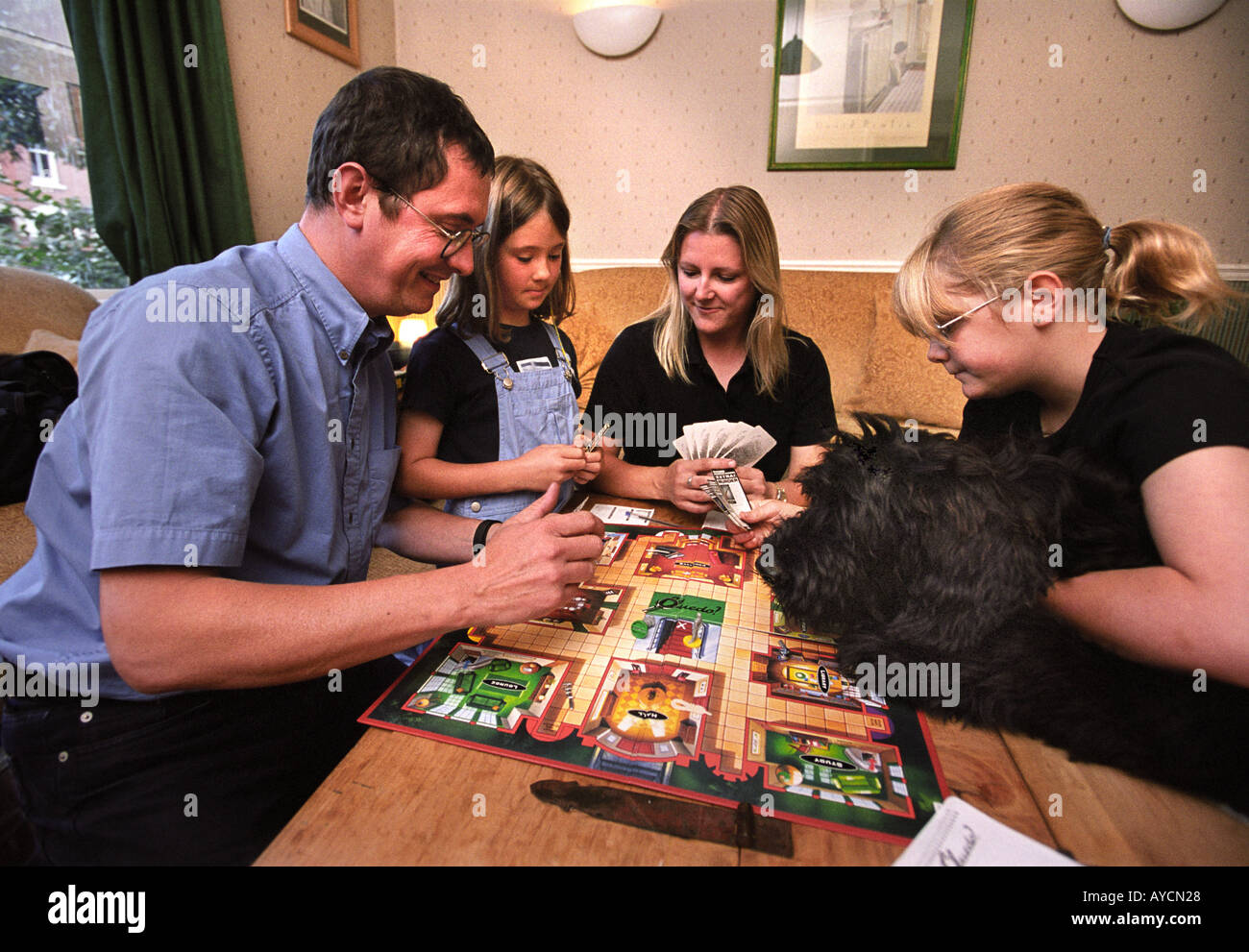 Une famille JOUANT UN JEU DE CLUEDO DANS LEUR SALON Banque D'Images