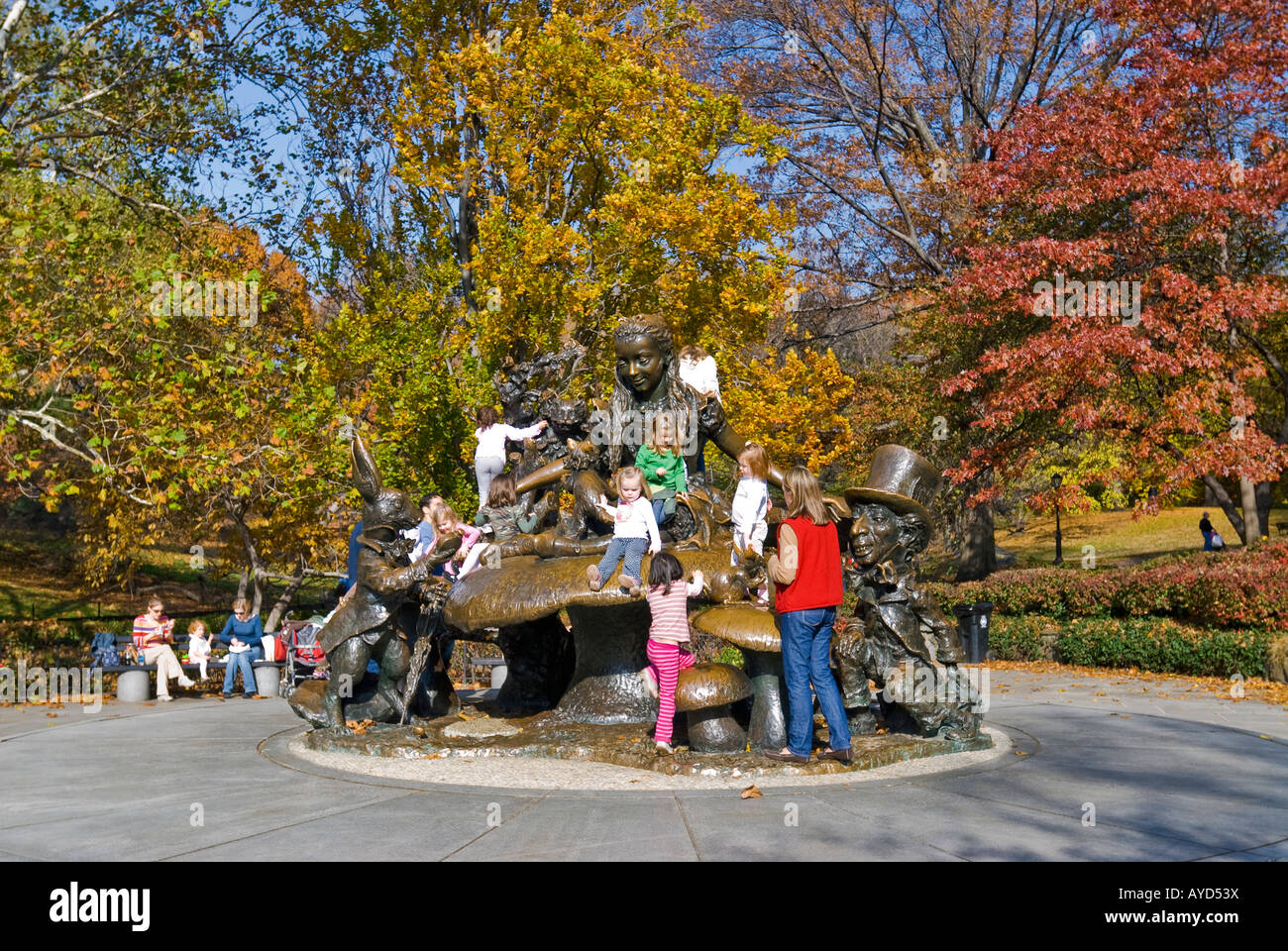 La ville de New York, les enfants monter sur le 'Alice in Wonderland' Statue in Central Park en automne. Banque D'Images