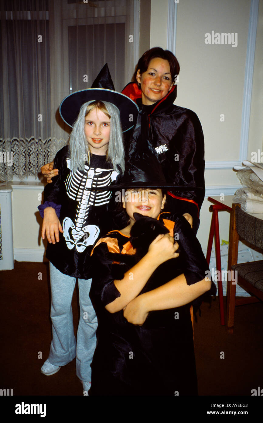 Jeune femme et des filles en costumes de Halloween Girl Holding Black Cat Banque D'Images