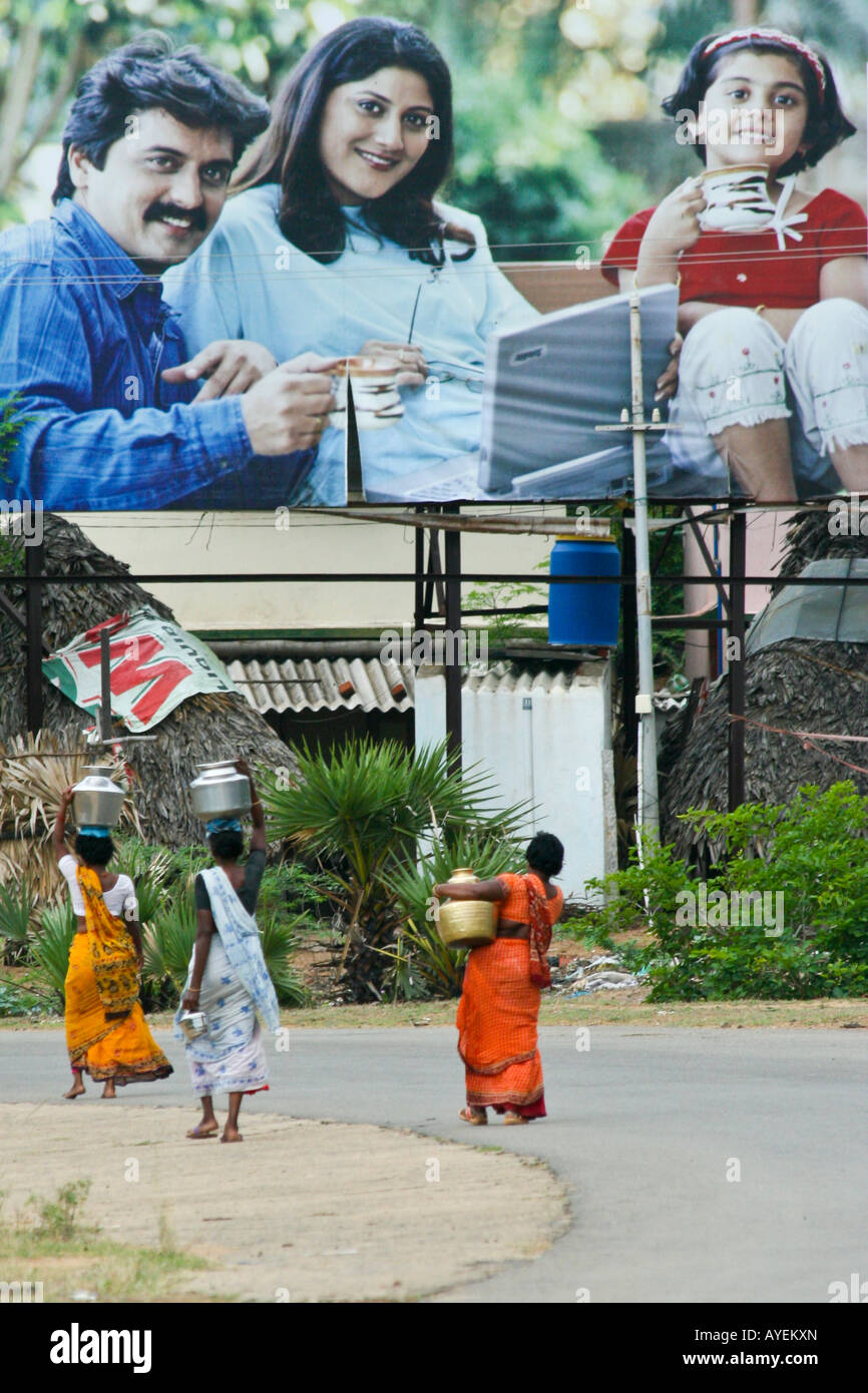 Les femmes portant de l'eau dans le cadre de l'aide de panneaux de la famille de l'ordinateur dans le Tamil Nadu en Inde du Sud Banque D'Images