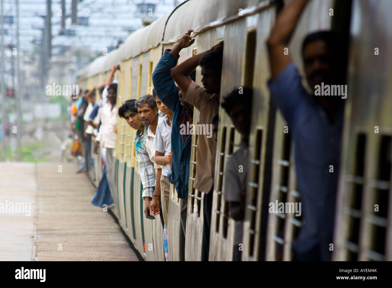 Riders incliné vers l'extérieur Portes d'un train arrivant à Chennai Inde du Sud Banque D'Images