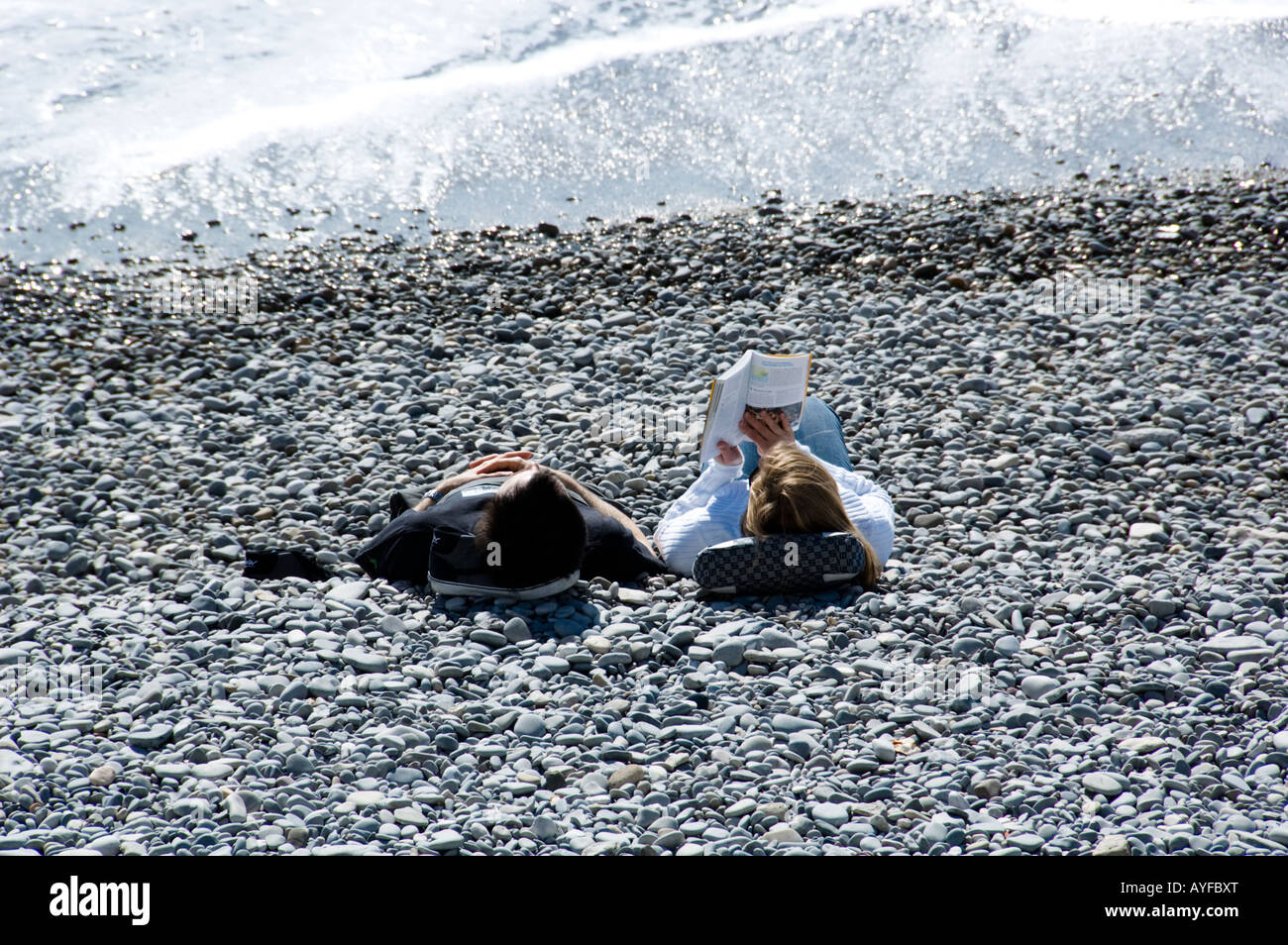 Un jeune couple de détente sur la plage de Nice, en France Banque D'Images