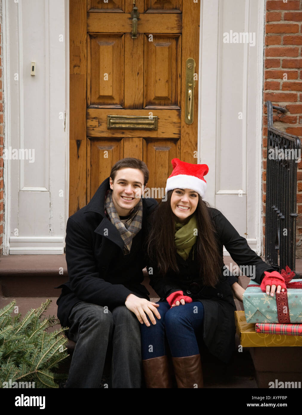 Couple avec arbre de Noël et cadeaux dans la partie avant de la trappe Banque D'Images