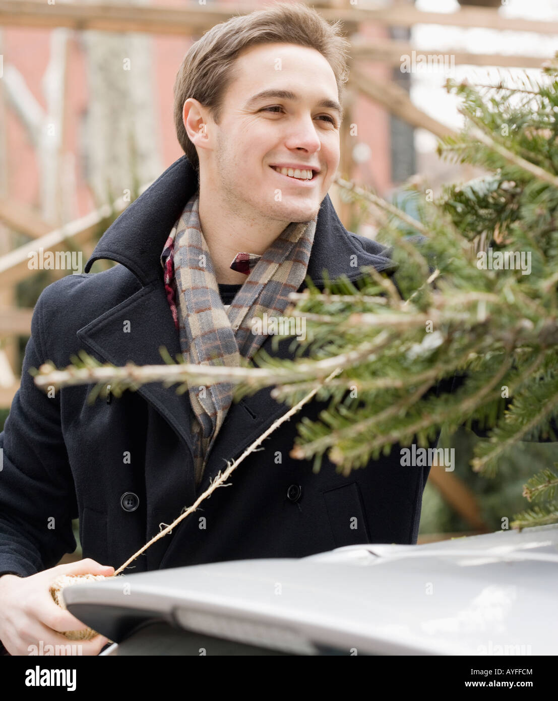 Man next to Christmas Tree on car Banque D'Images