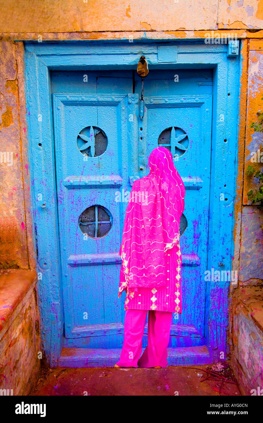 Femme dans la vieille ville de Delhi par une porte colorée, Inde Banque D'Images