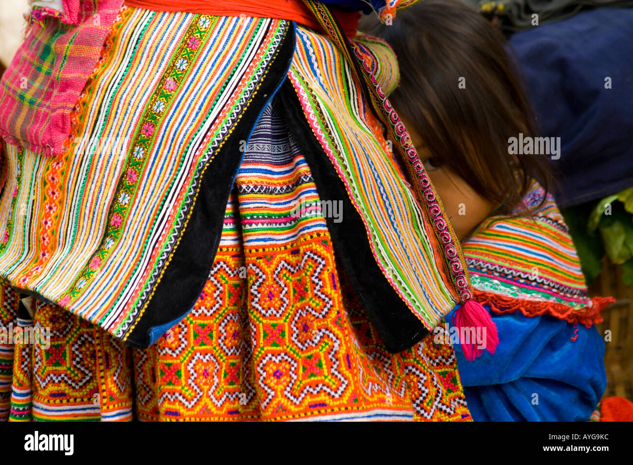 Jeune fille Flower Hmong qui se cachent dans sa mère s Jupe Bac Ha marché près de Sapa Vietnam Banque D'Images