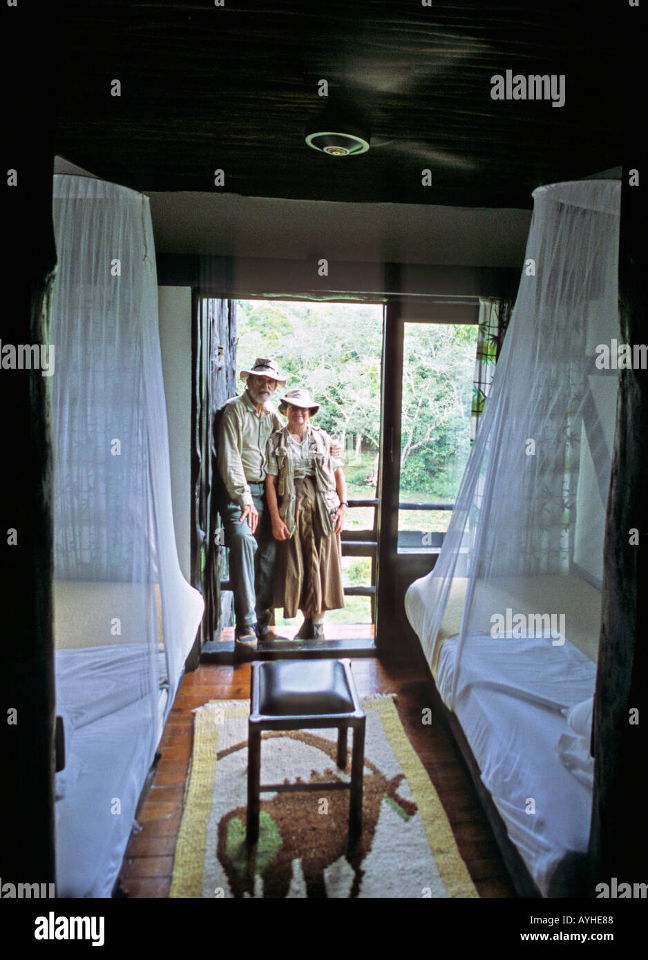 Afrique Kenya voyageurs Senior Shimba Hills dans safari vêtements debout sur leur balcon donnant sur l'abreuvoir des animaux Banque D'Images