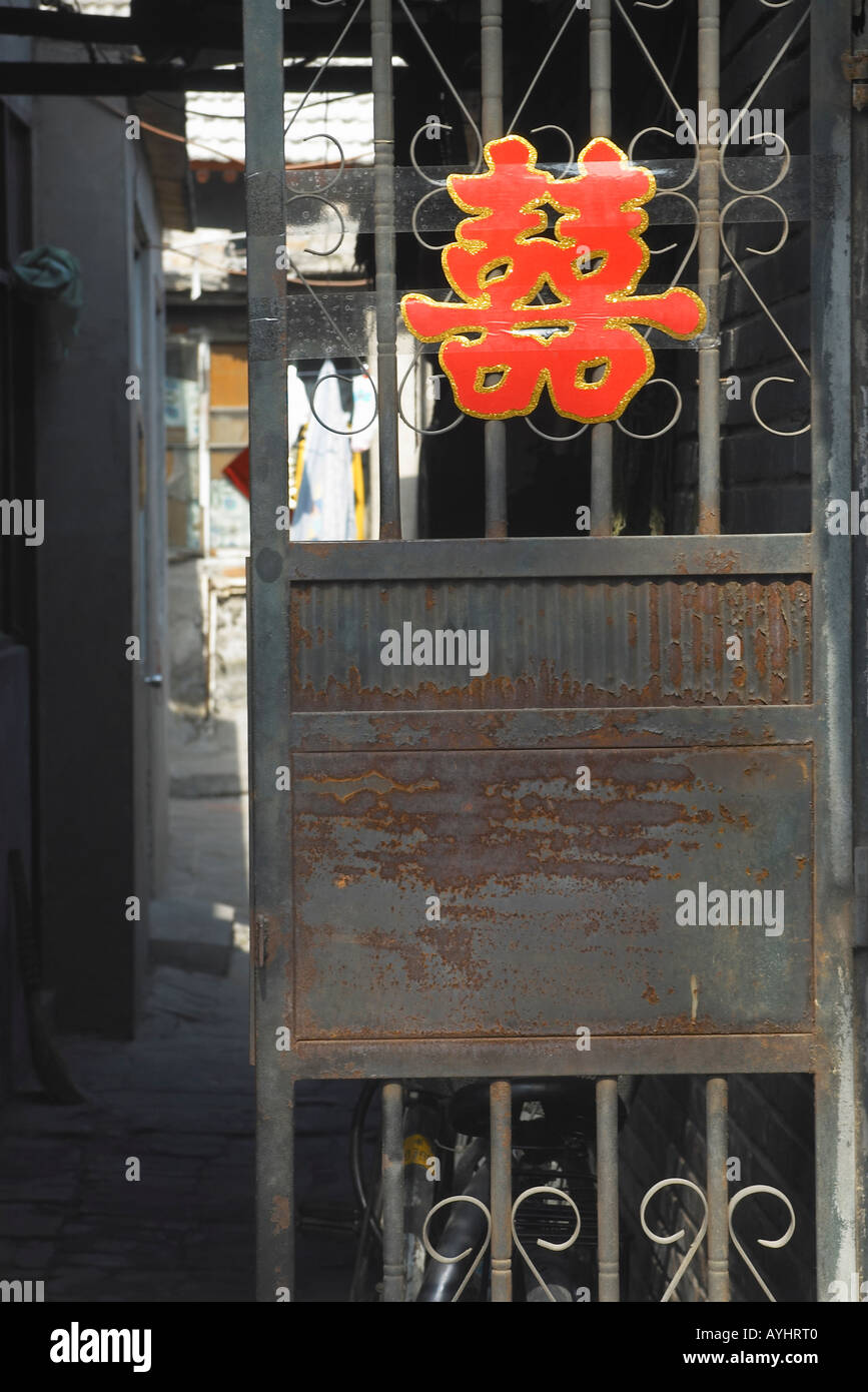 Porte en fer rouillée avec lettre chinoise rouge sur elle dans l'Ancien Beijing Chine Banque D'Images