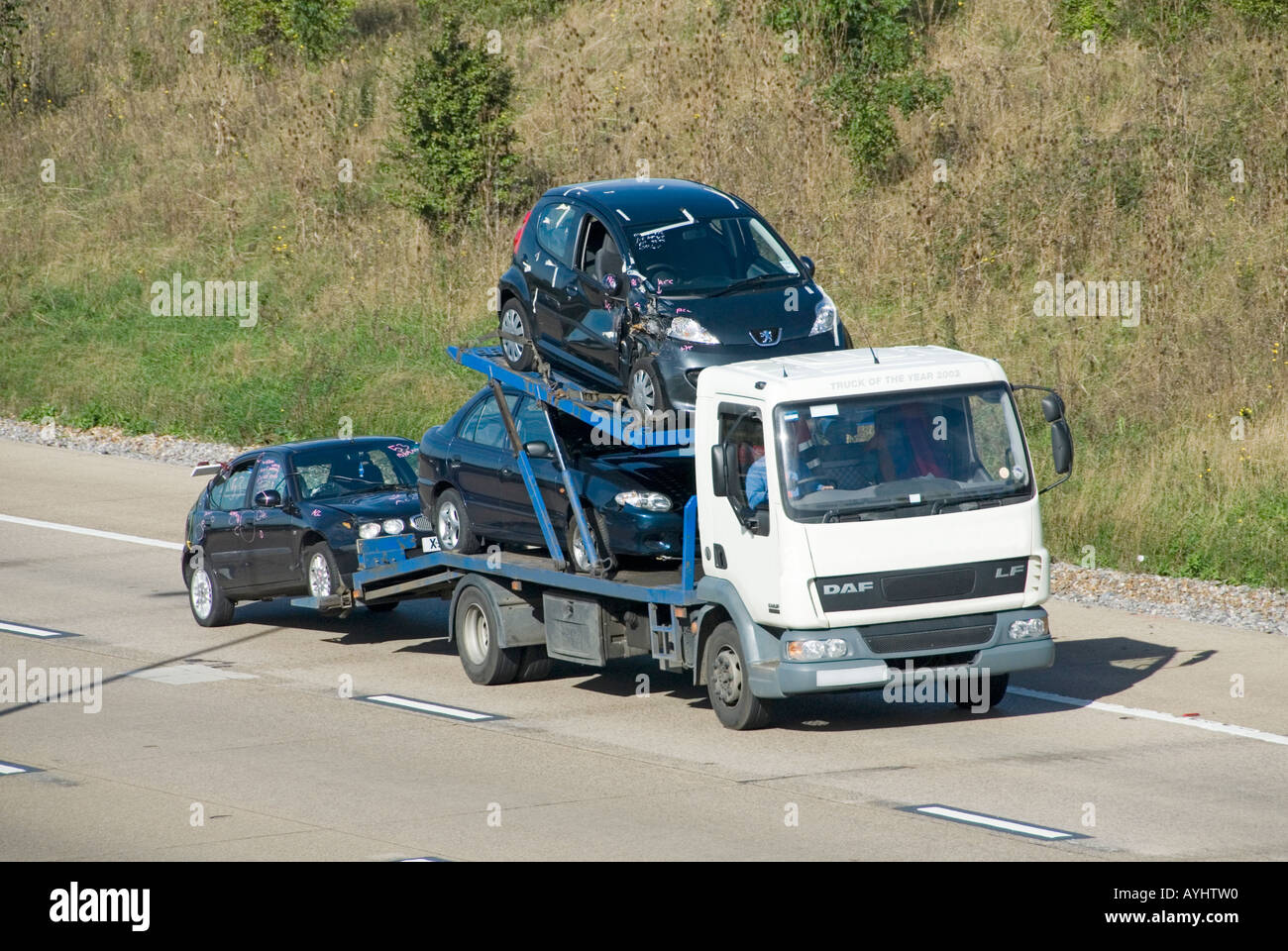 Autoroute M25 collection de voitures chargées non marqué la plaque de numéro de camion transportant des véhicules endommagés obscurci numériquement Banque D'Images