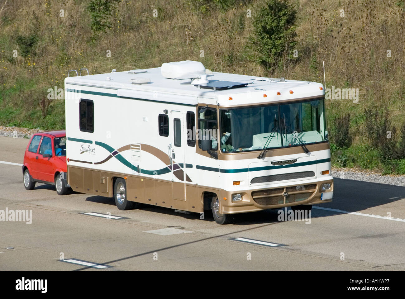 Vr véhicule récréatif avec à gauche le remorquage d'une petite voiture le long de l'autoroute britannique Banque D'Images