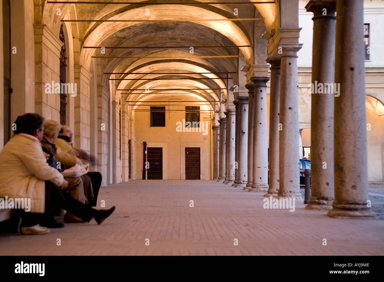 Les personnes qui prennent un repos sur un banc de marbre sous le porche de la maison de Mantegna, Mantoue (Mantova), Italie Banque D'Images