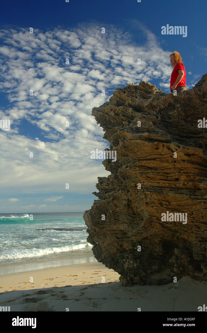 L'homme en chemise rouge regarde la mer Banque D'Images