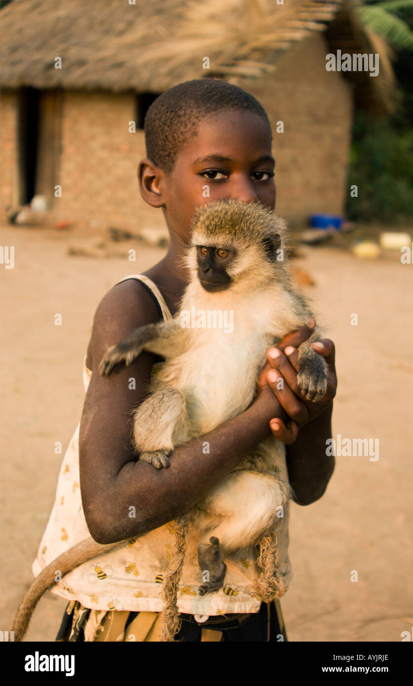 Jeune fille africaine avec un animal singe dans son village au bord du lac Victoria Ouganda Louloboka Banque D'Images