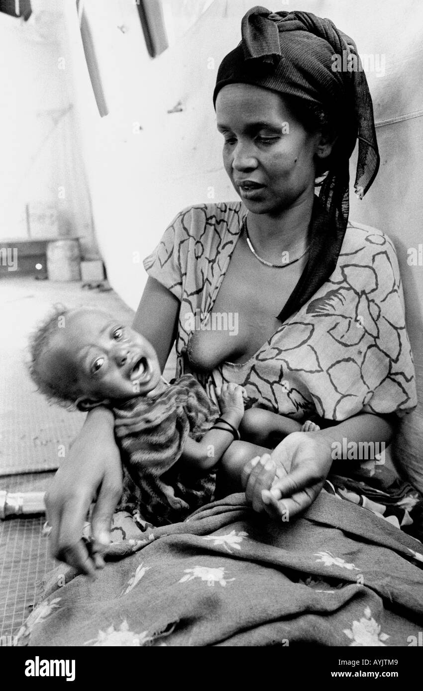 B/W d'une femme somalienne avec bébé émacié dans un centre d'alimentation pour réfugiés, Kebrehbeyah, Ethiopie, Afrique Banque D'Images