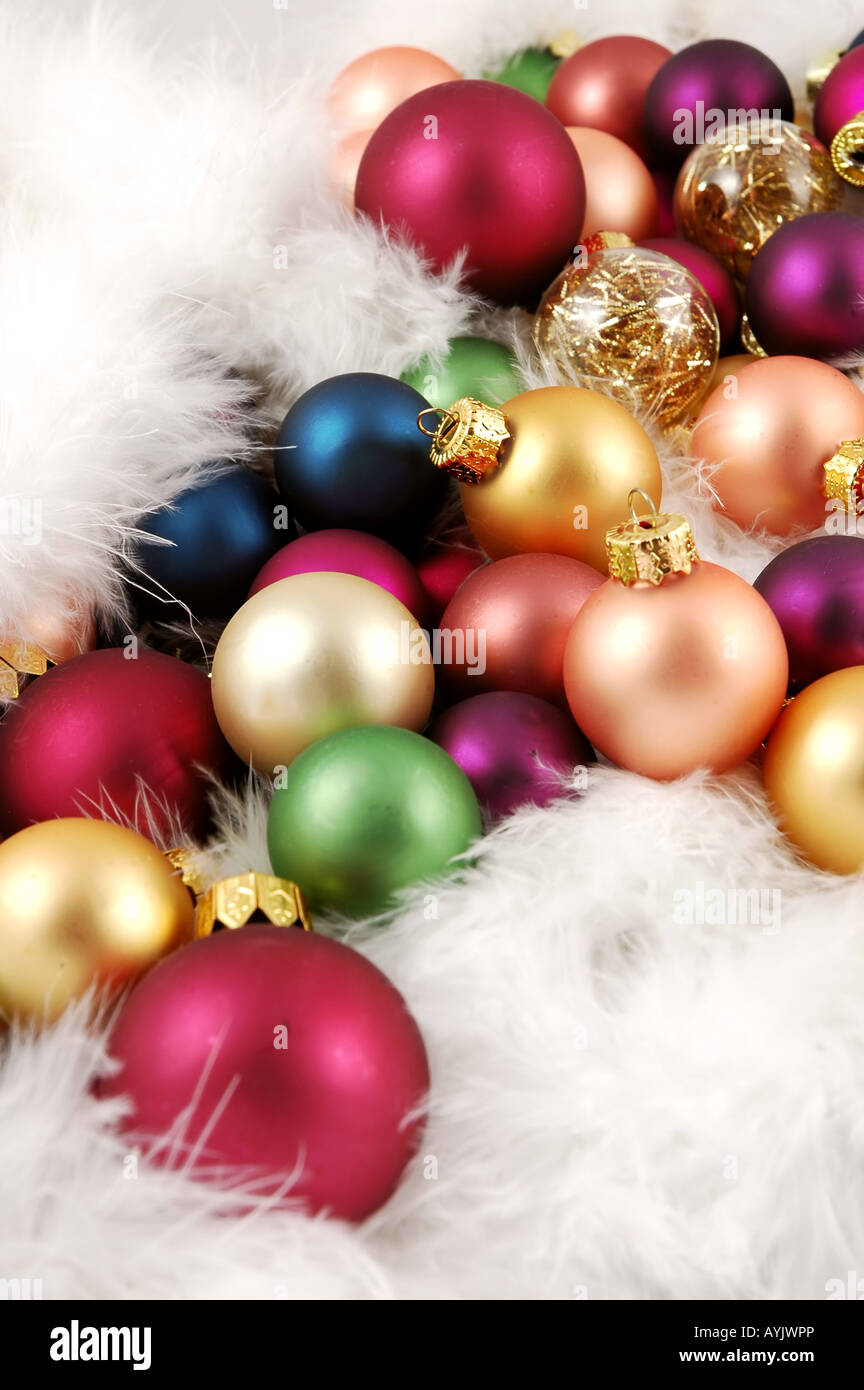Pile d'ornements de Noël niché dans les plumes blanches Banque D'Images