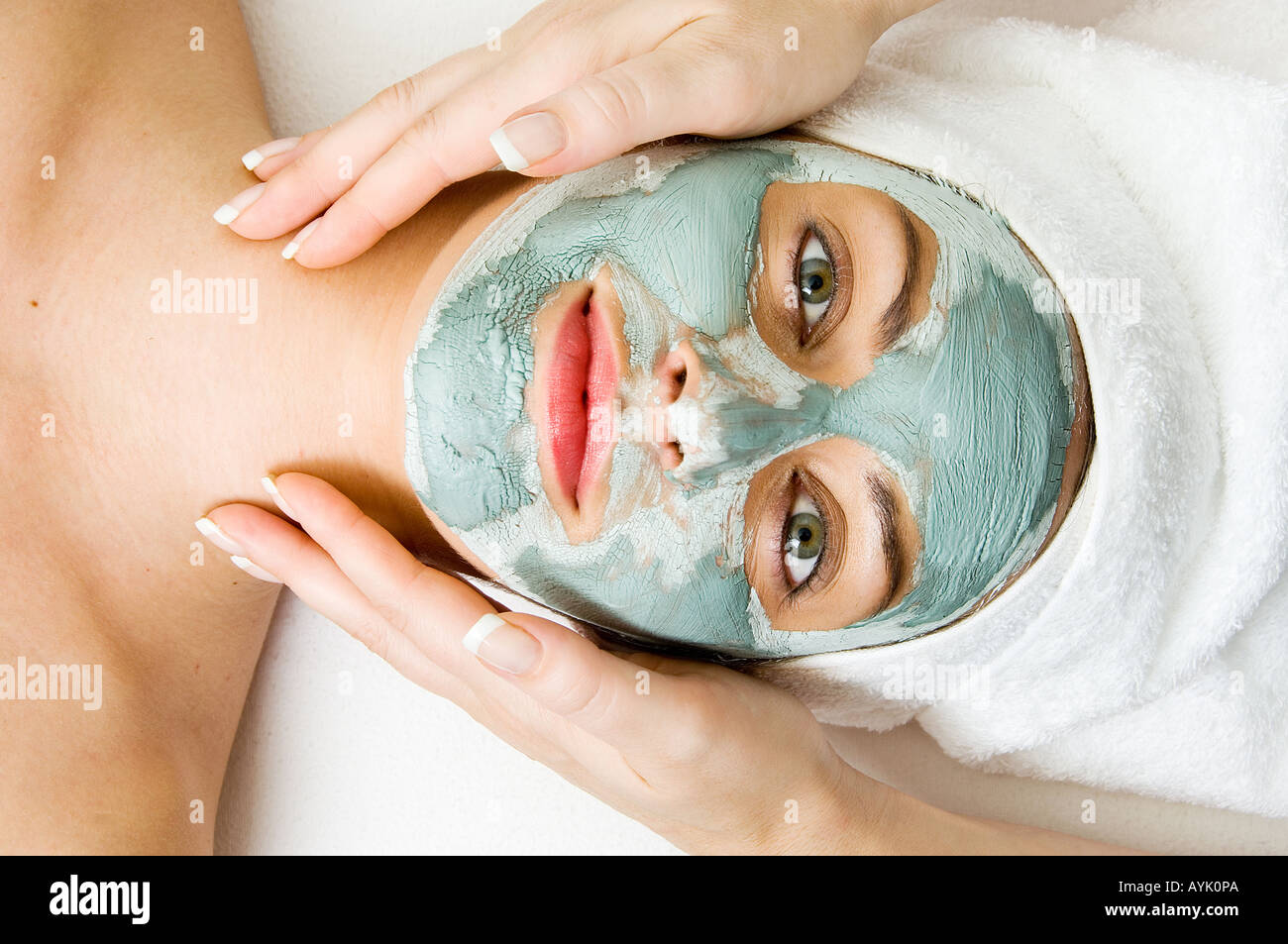 Femme avec pack de boue visage massage réception Banque D'Images