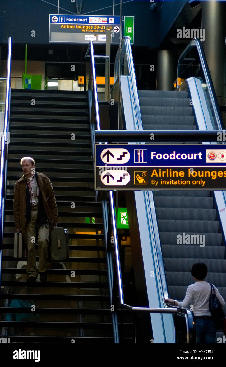 Amsterdam, les voyageurs à l'escalator à l'aéroport Schiphol Banque D'Images