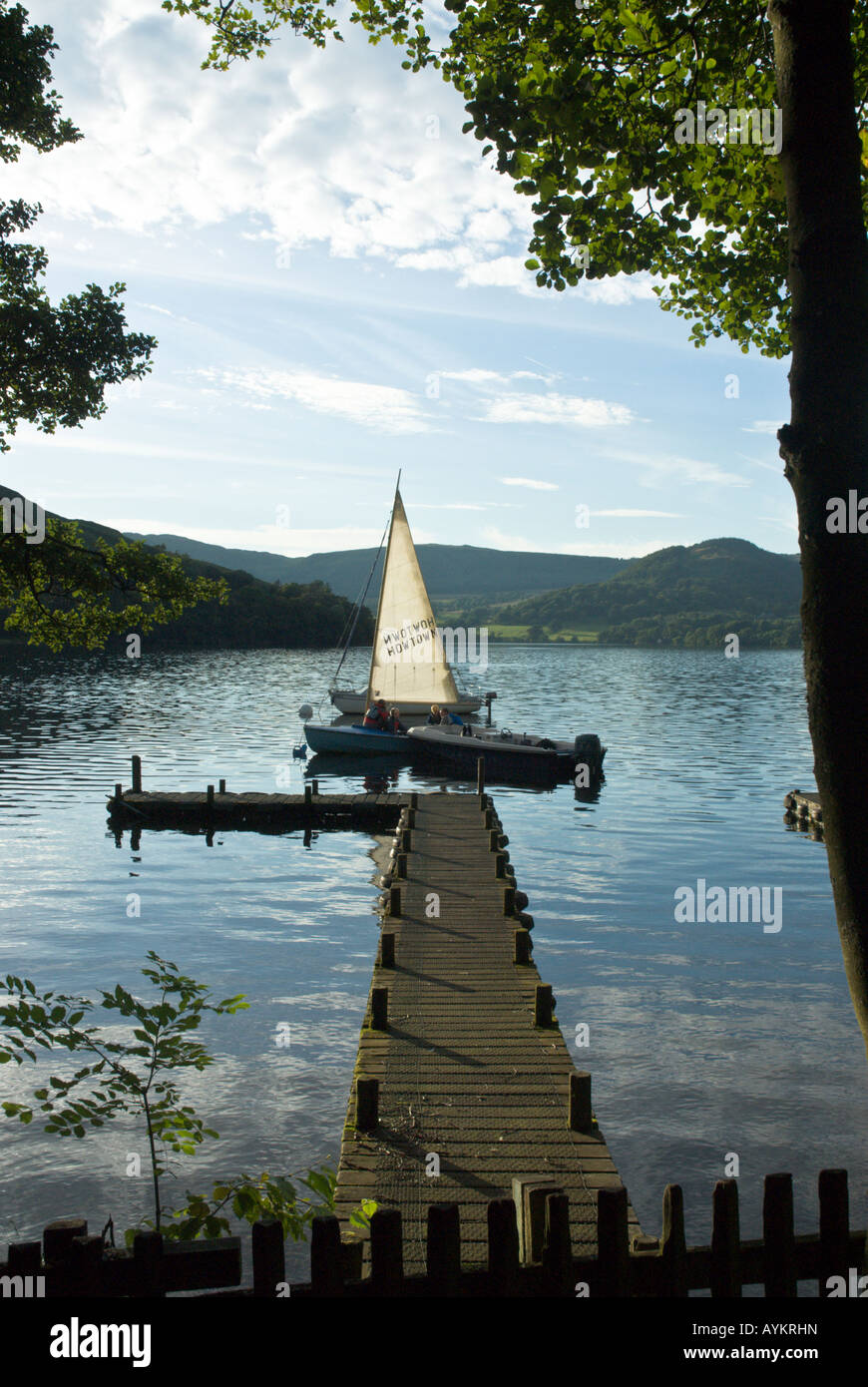 Petite voile à dingies Howtown Bay, Ullswater Lake District dans la soirée le soleil d'été avec les enfants et les adultes à côté d'une jetée Banque D'Images