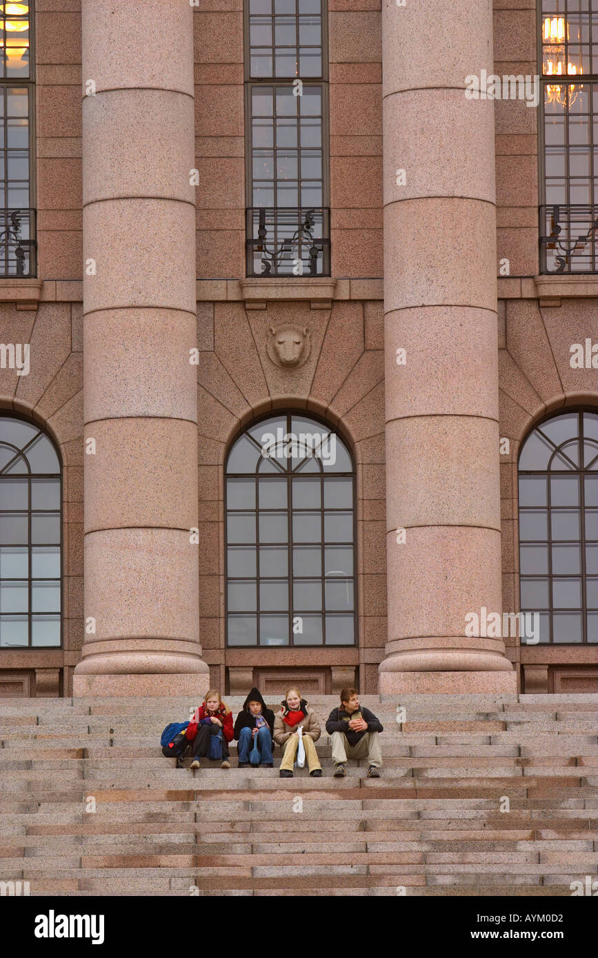 Les jeunes gens assis sur les marches de la Maison du Parlement finlandais, Helsinki, Finlande Banque D'Images