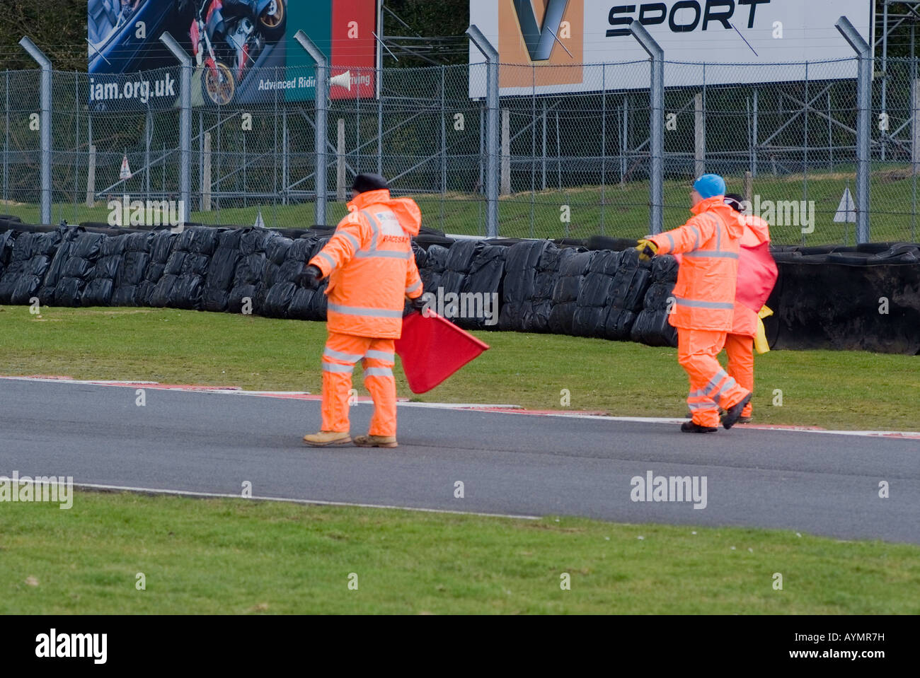 Track Marshalls avec drapeaux rouges de circuit de compensation après la course de moto Trafic à Oulton Park Motor Racing Track Cheshire UK Banque D'Images