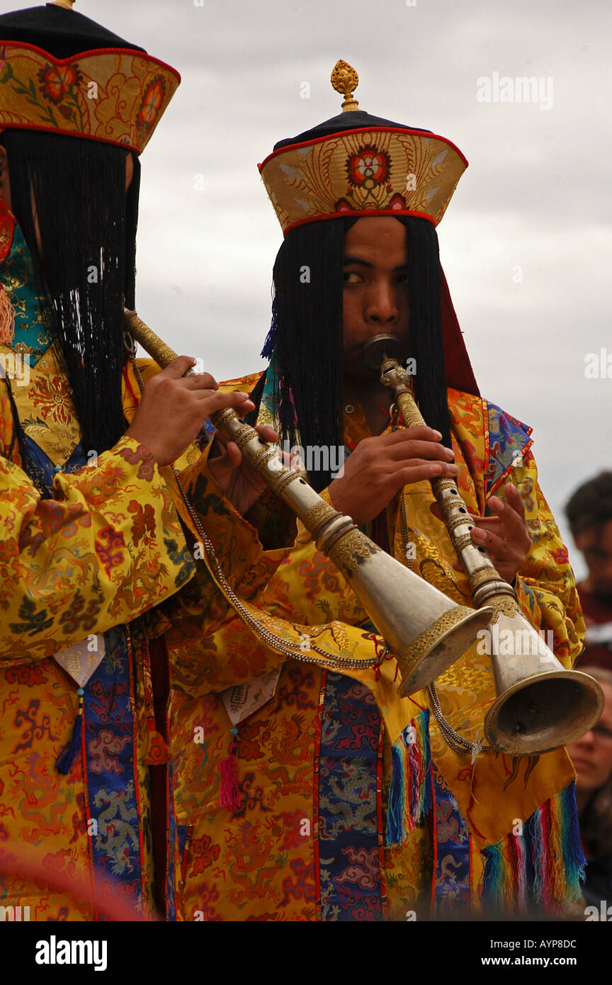 Moines bouddhistes tibétains en prive colorés jouant la musique rituelle sur trompettes Banque D'Images