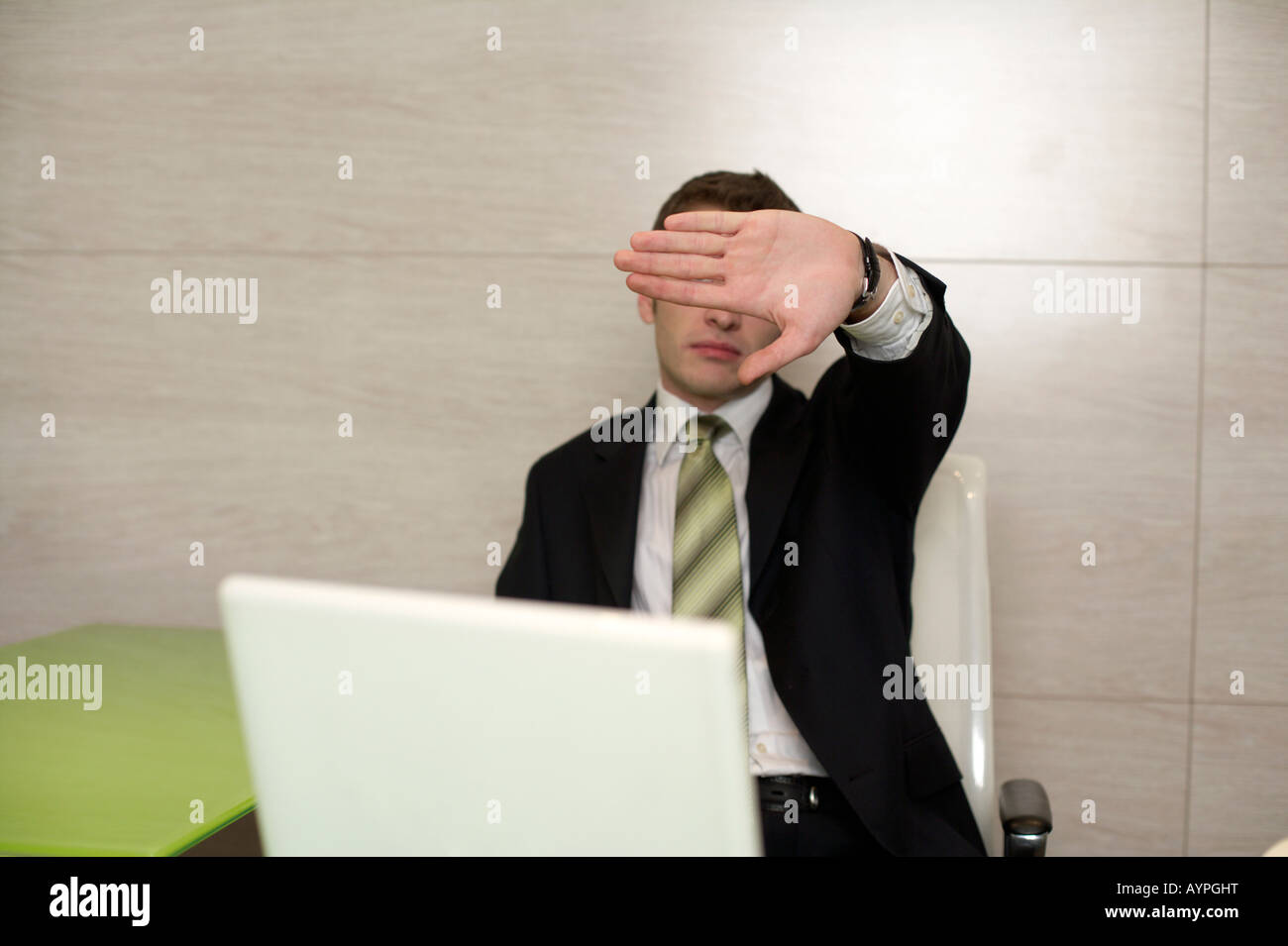 Businessman at desktop, couvrant son visage Banque D'Images