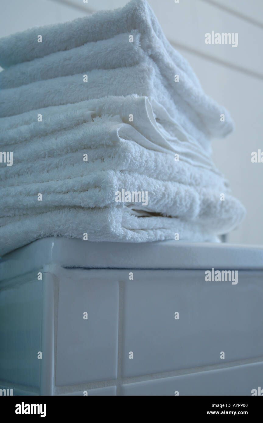 Tas de serviettes blanches placées sur le bord d'une baignoire Banque D'Images