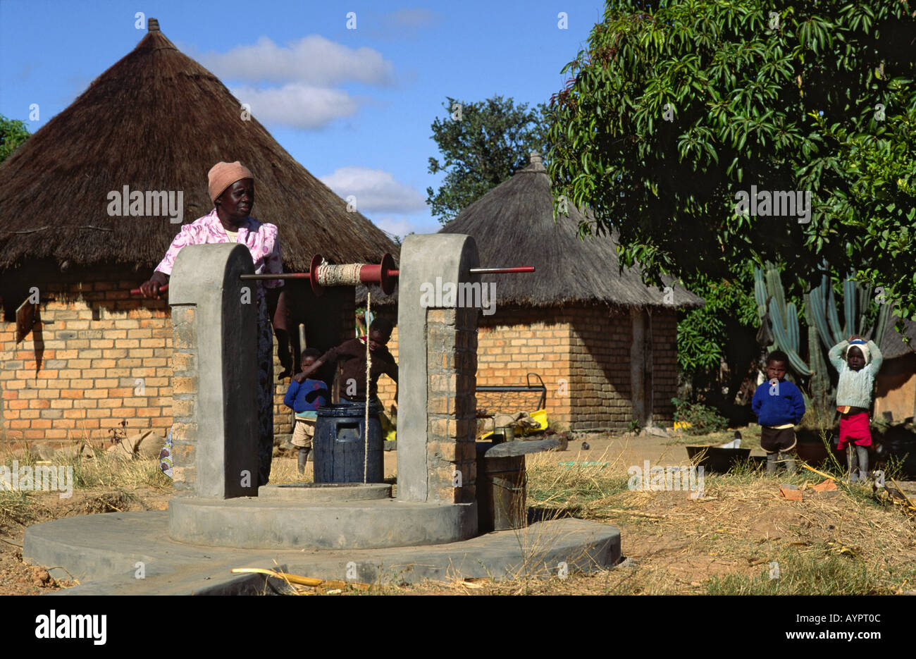 Une femme qui lève l'eau de la nouvelle famille améliorée bien qui fournira de l'eau potable propre à plusieurs autres familles aussi. Kwekwe, Zimbabwe Banque D'Images