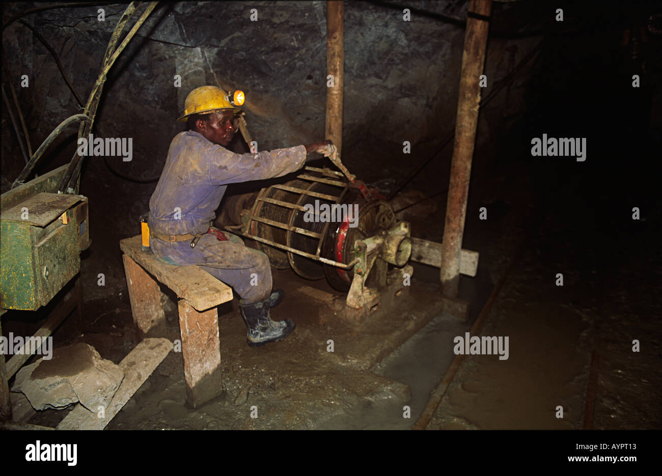 Miner qui travaille sur le matériel de bobinage de l'ascenseur des mineurs souterrain à Jumbo goldmine, Mazowe, Zimbabwe Banque D'Images