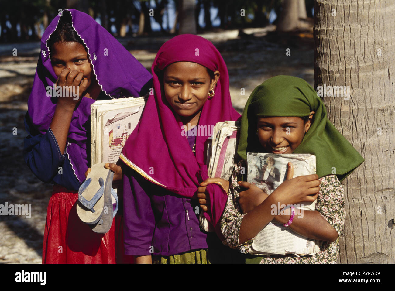 Trois étudiants musulmans fille timide sourire rire livres dans la main tête couverte d'aller à l'école en Asie Inde Lakshadweep Island Kadmat Banque D'Images