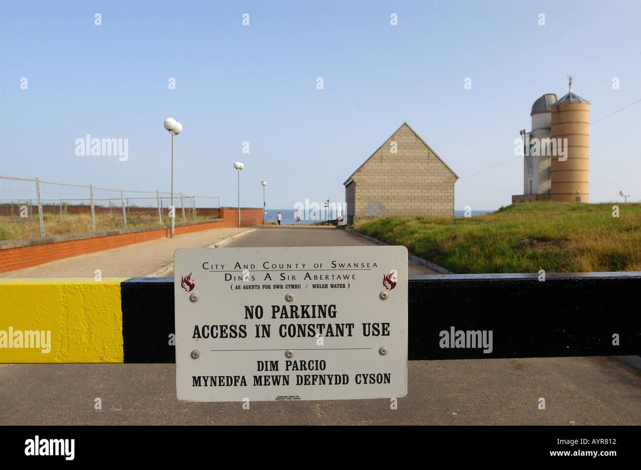 Barrière avec deux langues anglais et gallois signe No parking près de Swansea Wales UK. Panneau d'avertissement bilingue sur une barrière routière dans le sud du pays de Galles. Banque D'Images