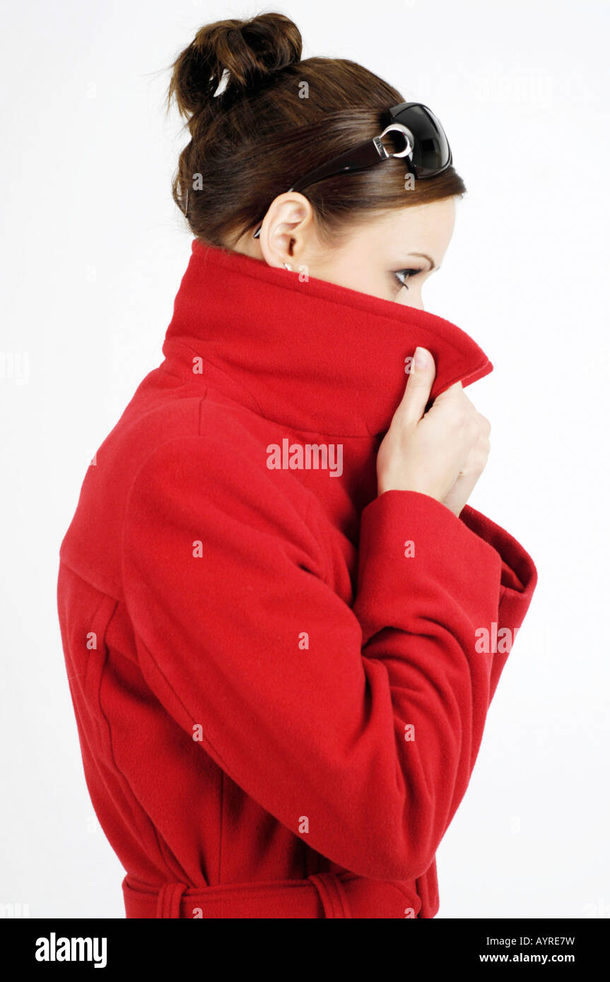 Jeune femme portant des lunettes et manteau rouge en relevant son col Photo  Stock - Alamy