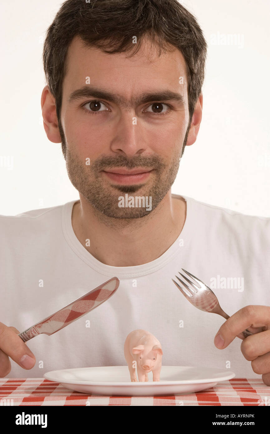 Man holding couverts sur un cochon sur une assiette, la nutrition, les aliments génétiquement modifiés Banque D'Images