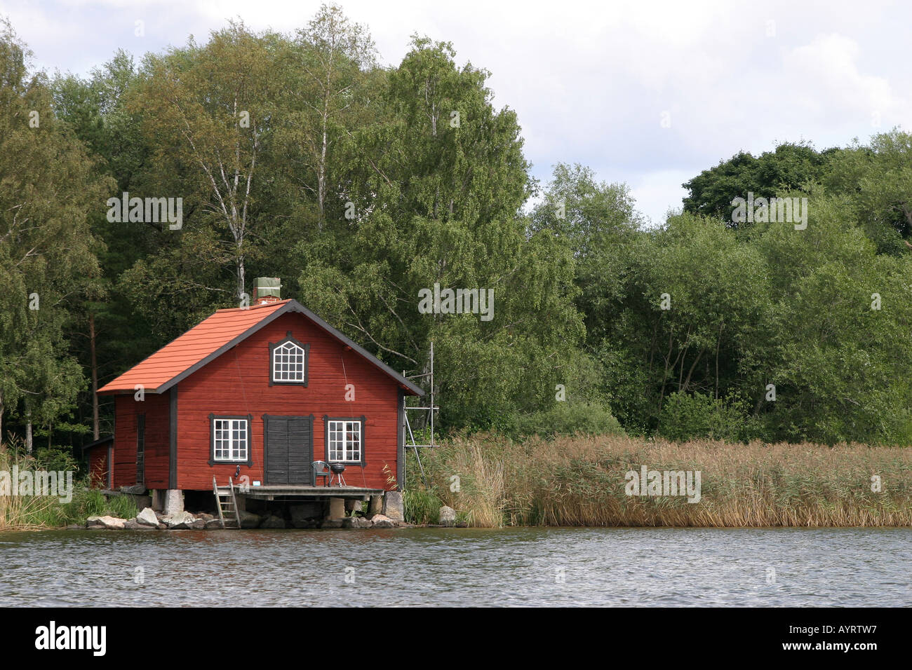 Maison rouge par un lac en Suède Banque D'Images