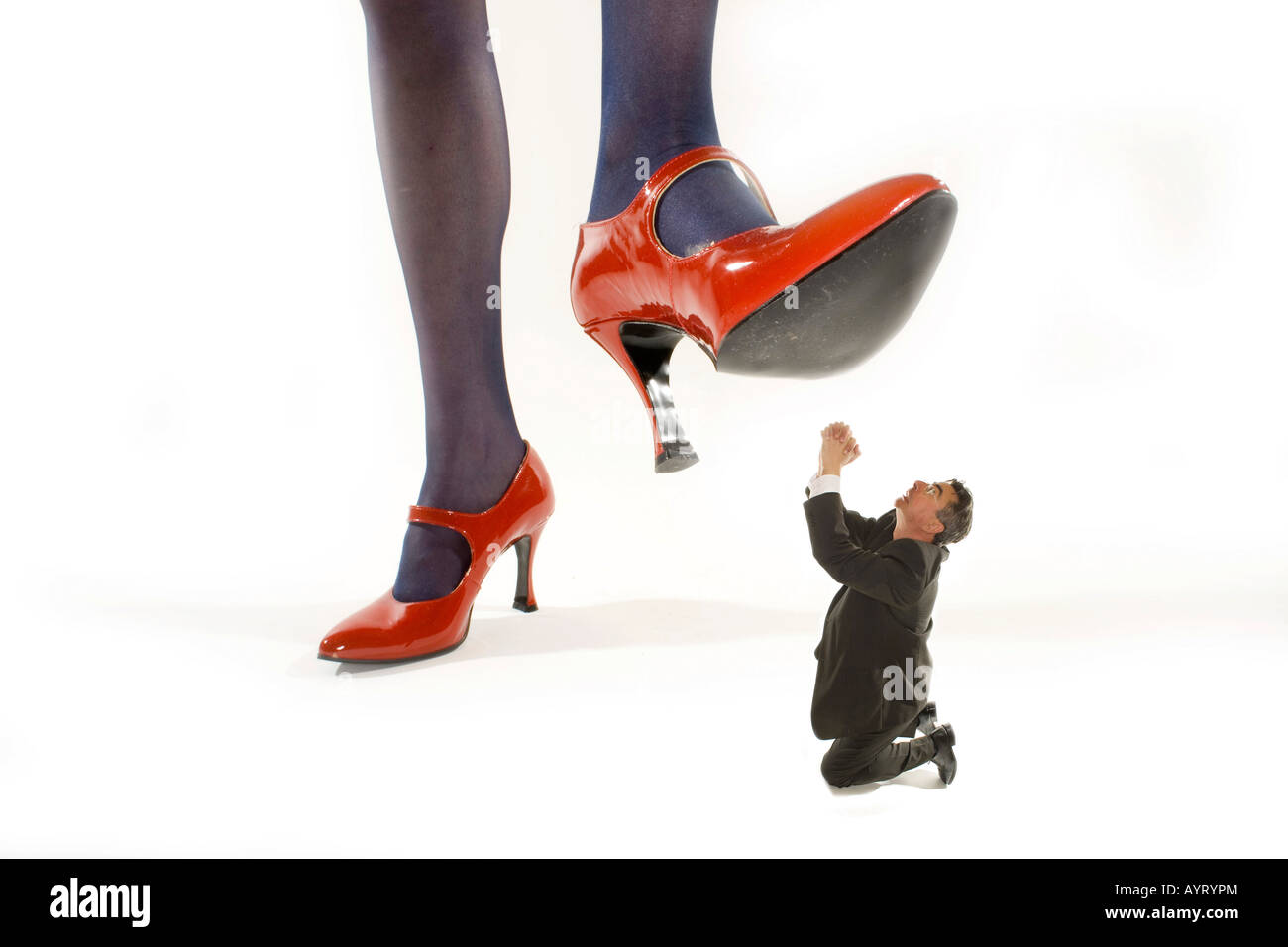 Woman in red High heels marcher sur un homme ratatiné Banque D'Images