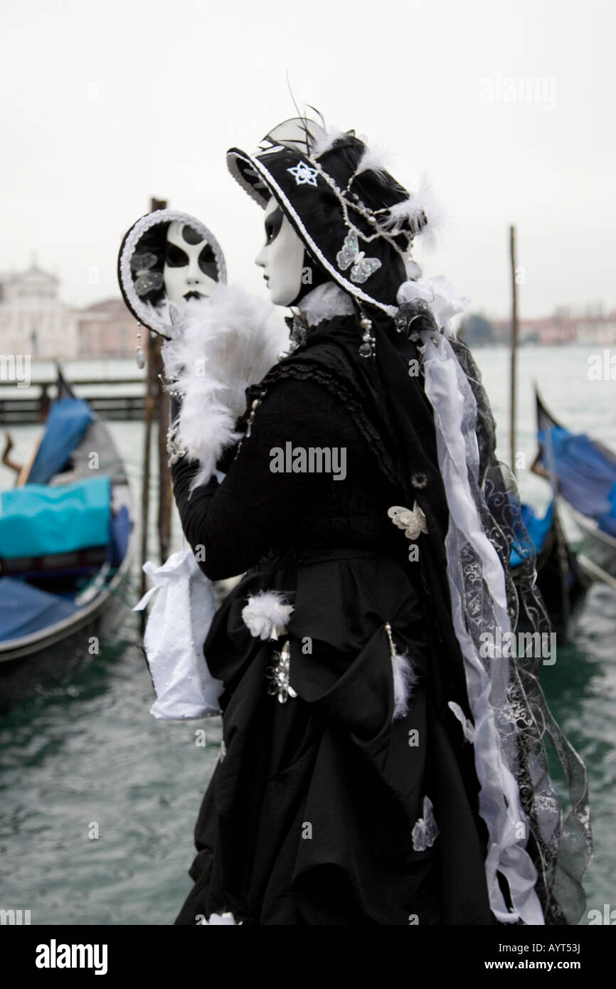 Le noir et blanc costume et masque avec miroir en face des télécabines, Carnevale di Venezia, Carnaval de Venise, Italie Banque D'Images